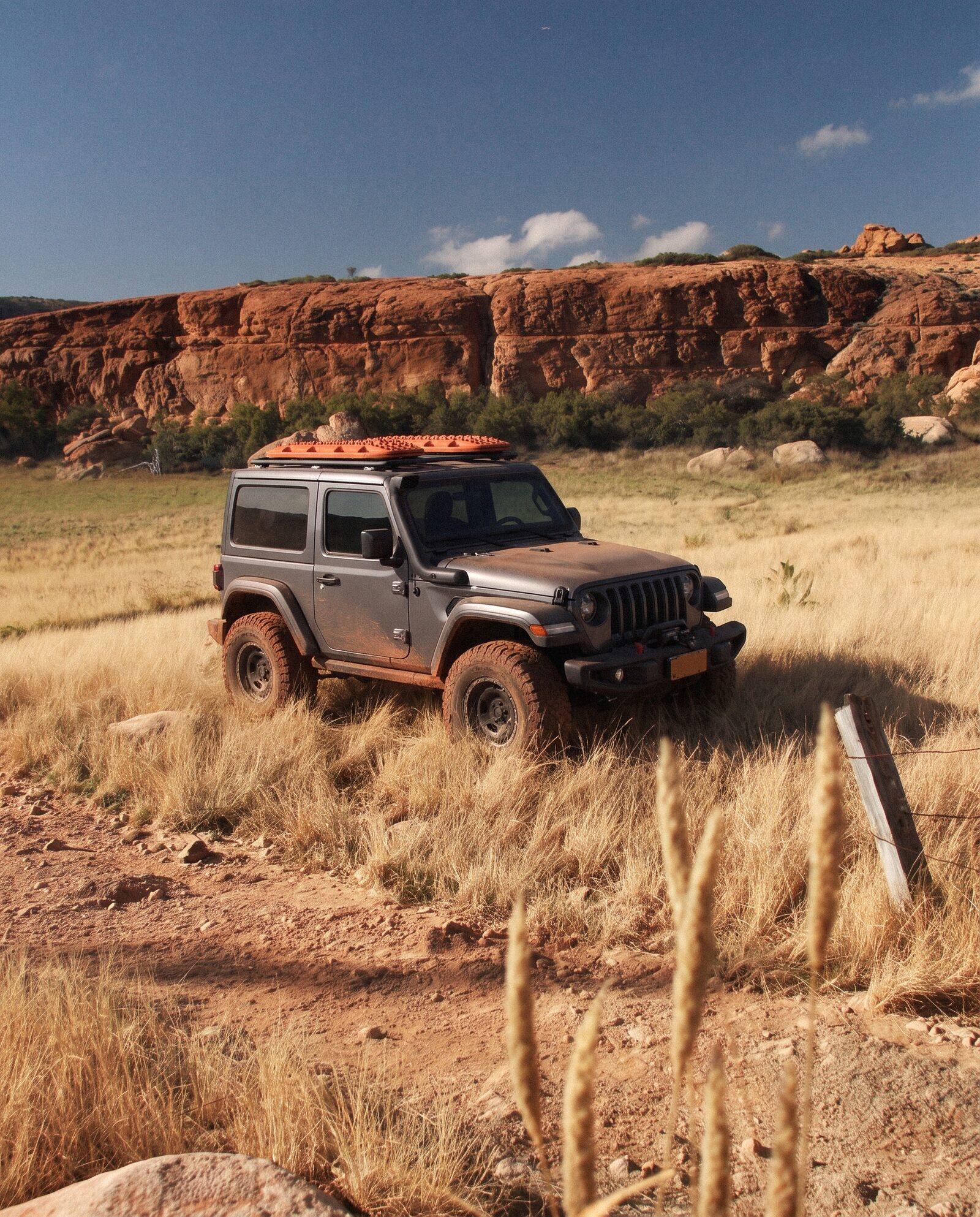 Off road campaign image produced by the studio: fitted 4WD with recovery boards below a red rock escarpment