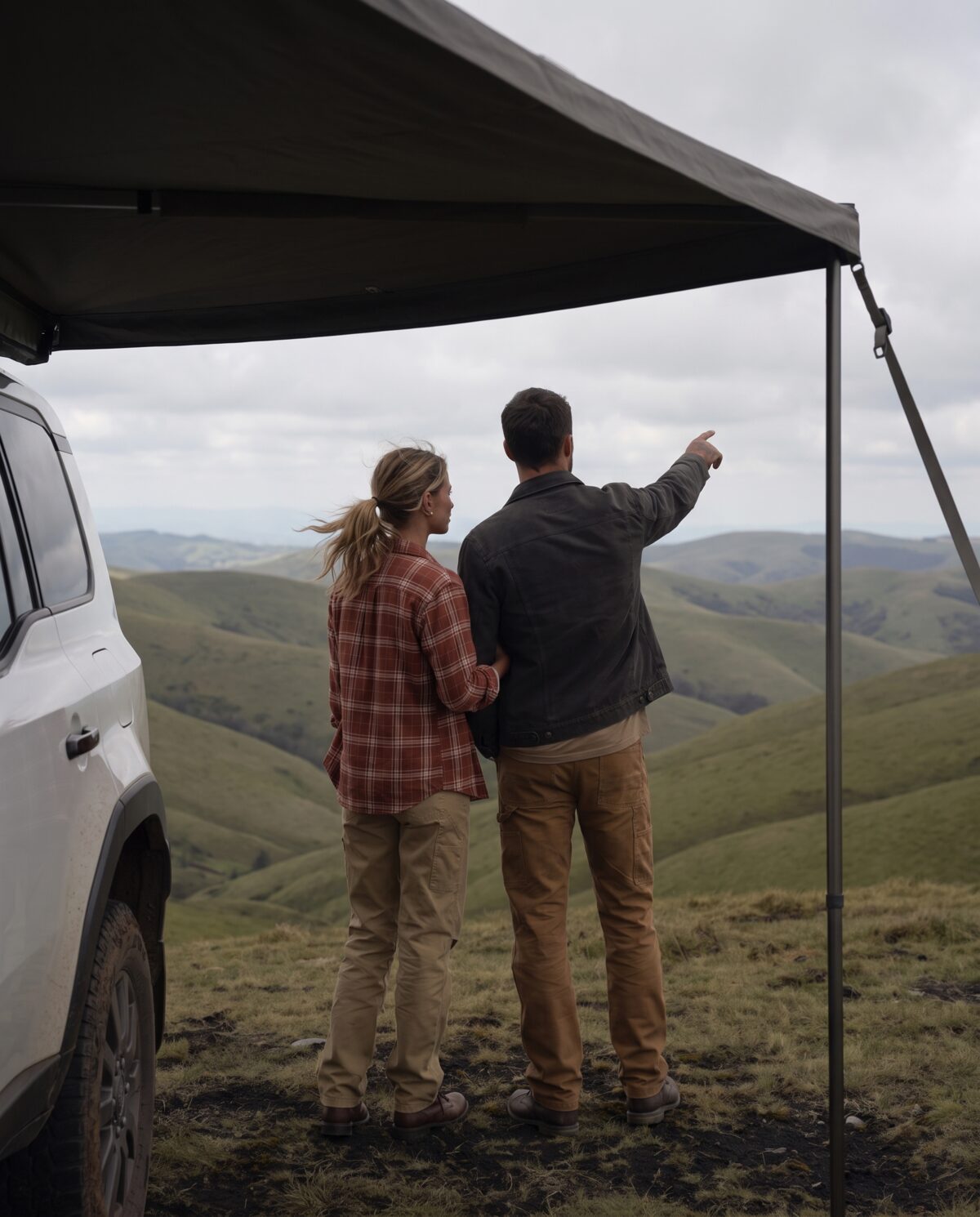 Couple under the awning looking out over rolling hills